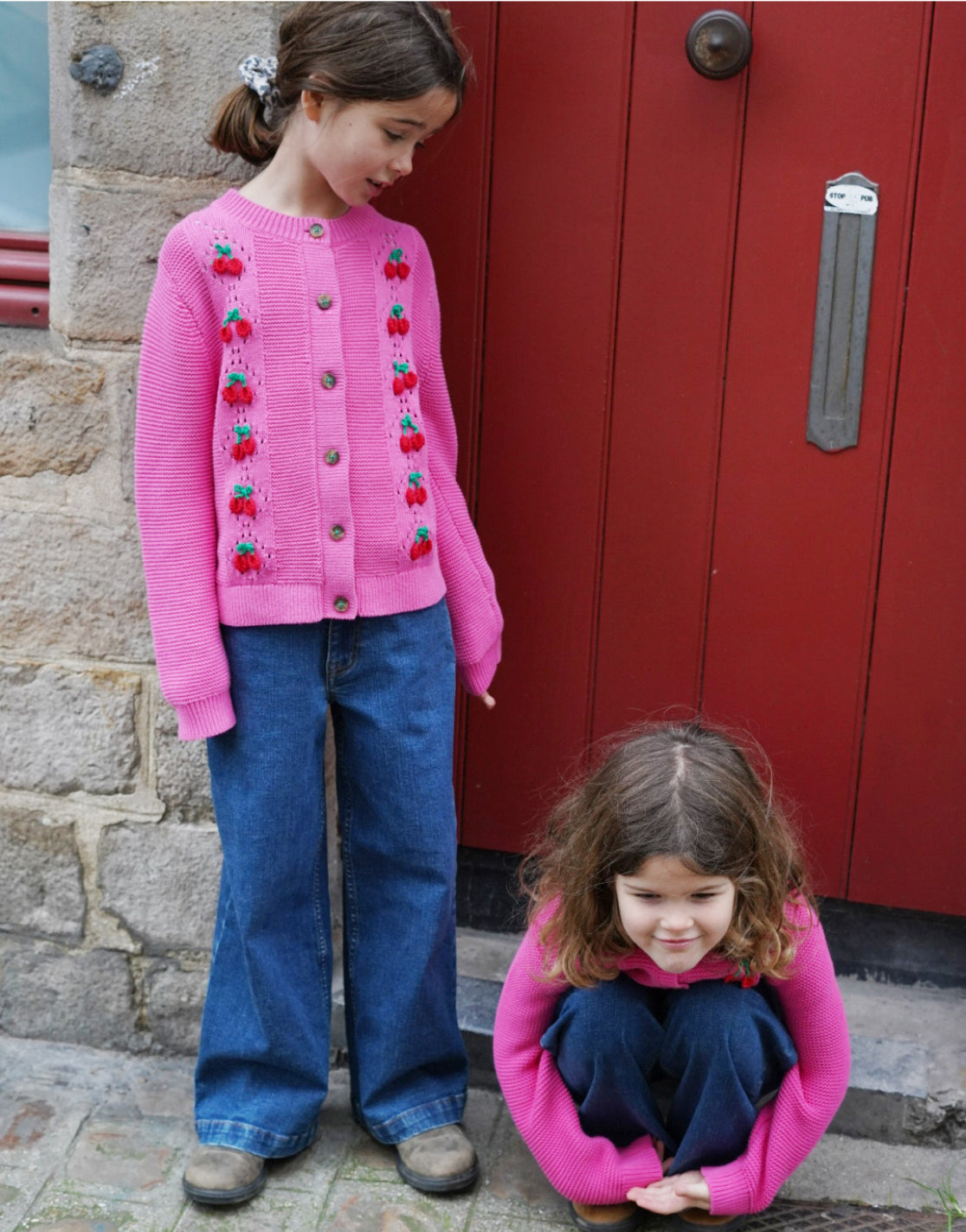 girl standing next to a girl sitting down