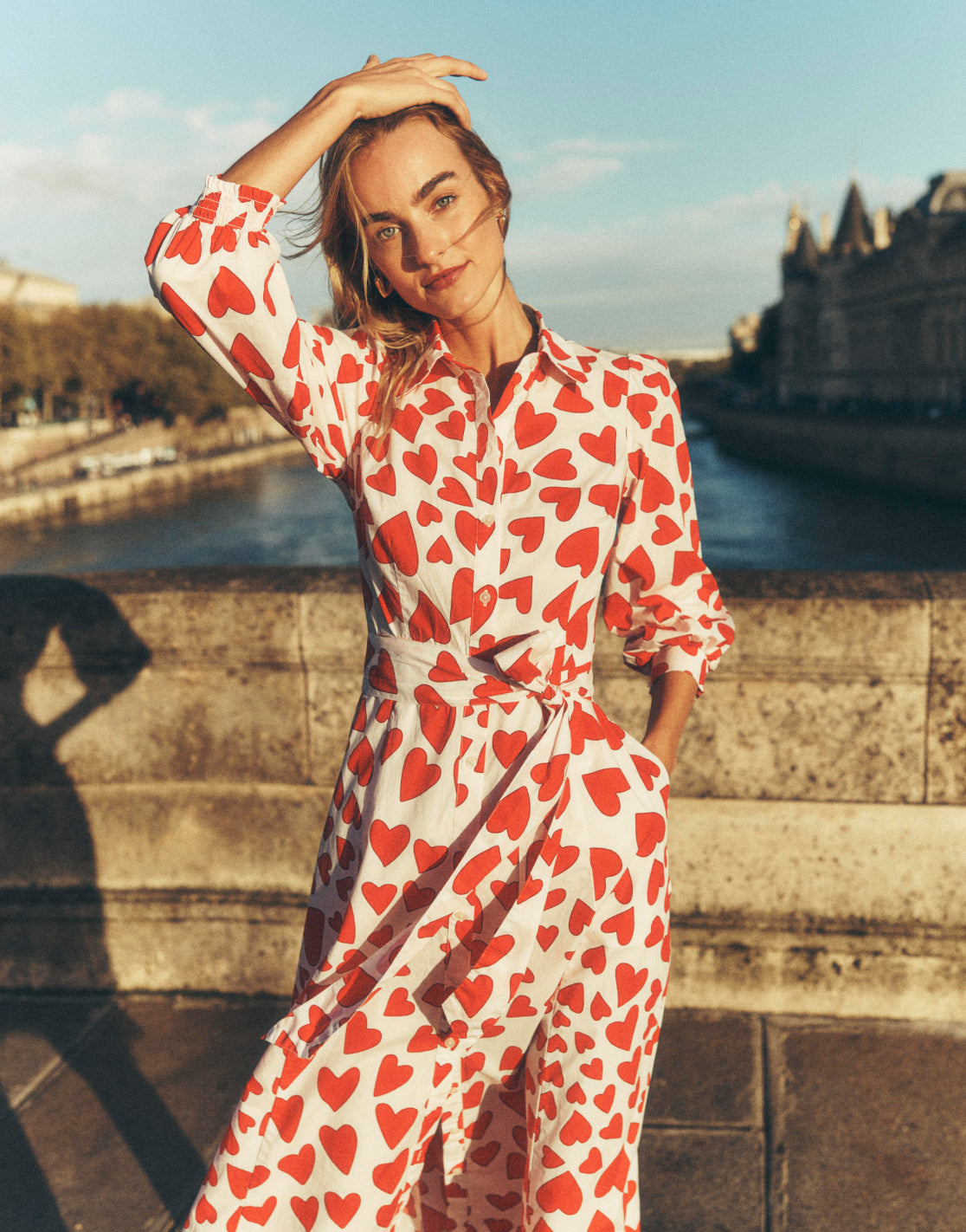 Woman stood on a bridge in Paris wearing a Boden love heart dress