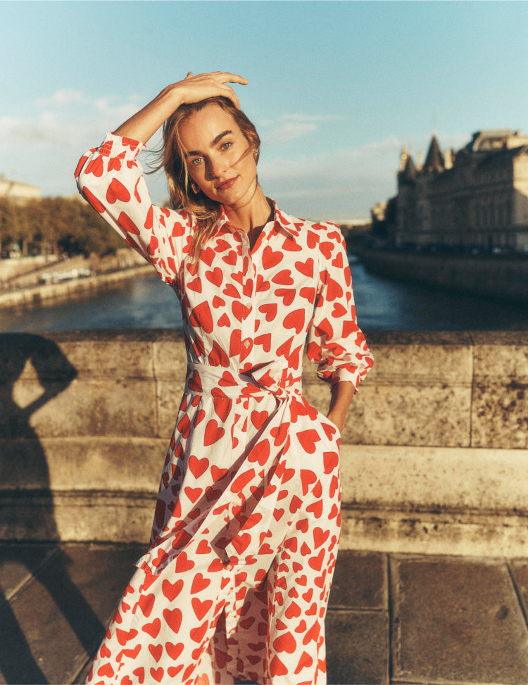 Woman stood on a bridge in Paris wearing a Boden love heart dress