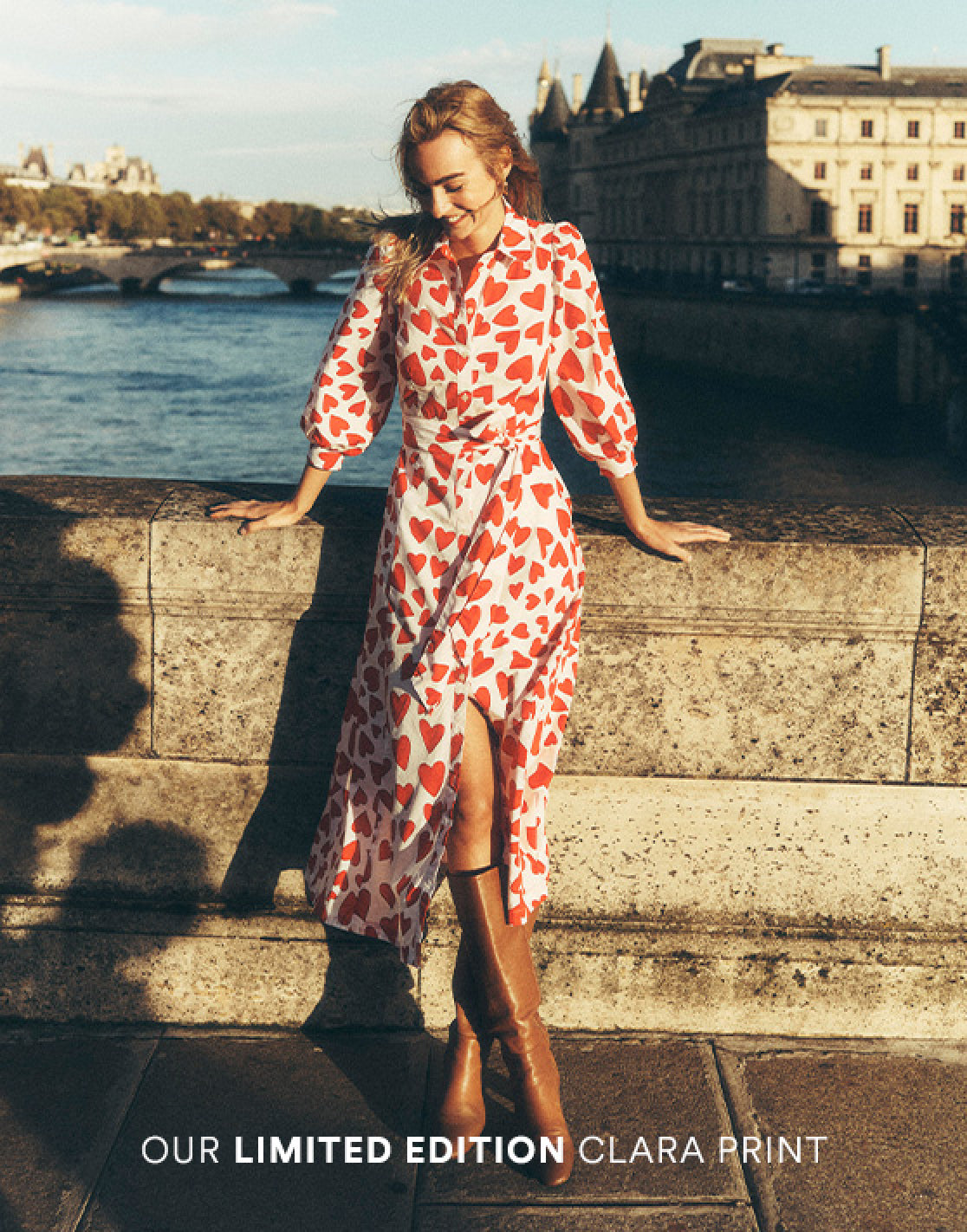 Annotated picture of a woman stood on a bridge in Paris wearing a Boden love heart dress