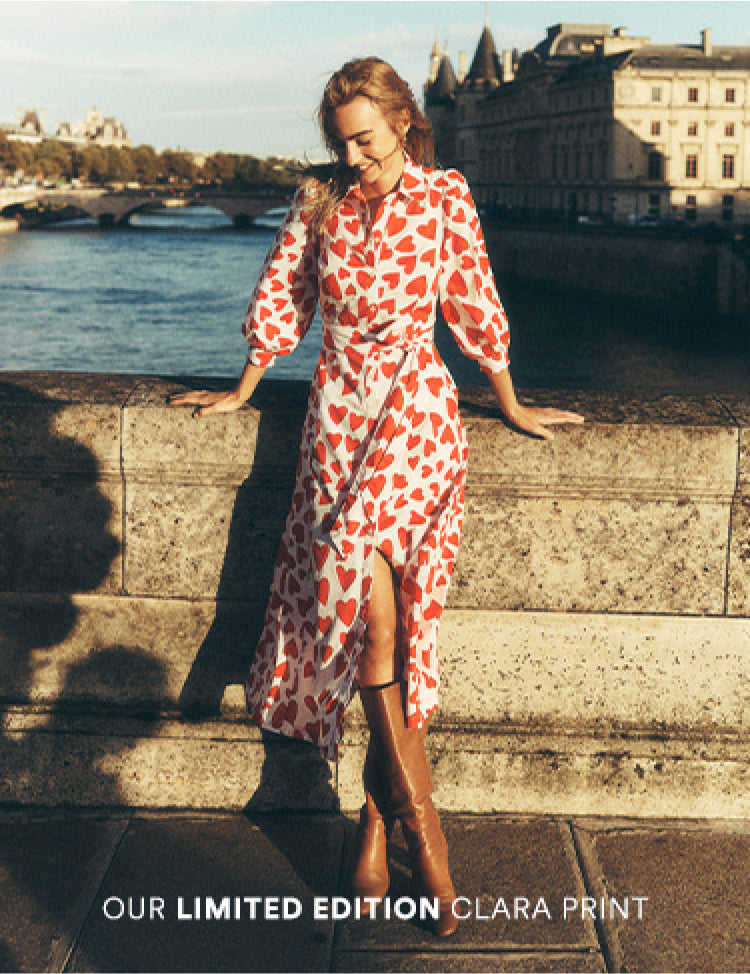 Annotated picture of a woman stood on a bridge in Paris wearing a Boden love heart dress