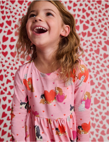 Girl laughing, wearing pink Boden cats and dogs dress