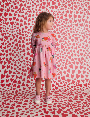 Girl wearing pink Boden cats and dogs dress