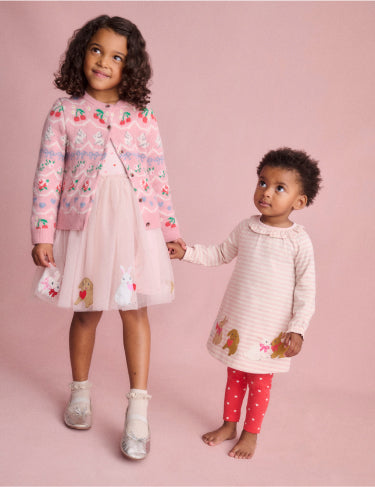 Girl and baby holding hands, wearing pink Boden bunny dresses