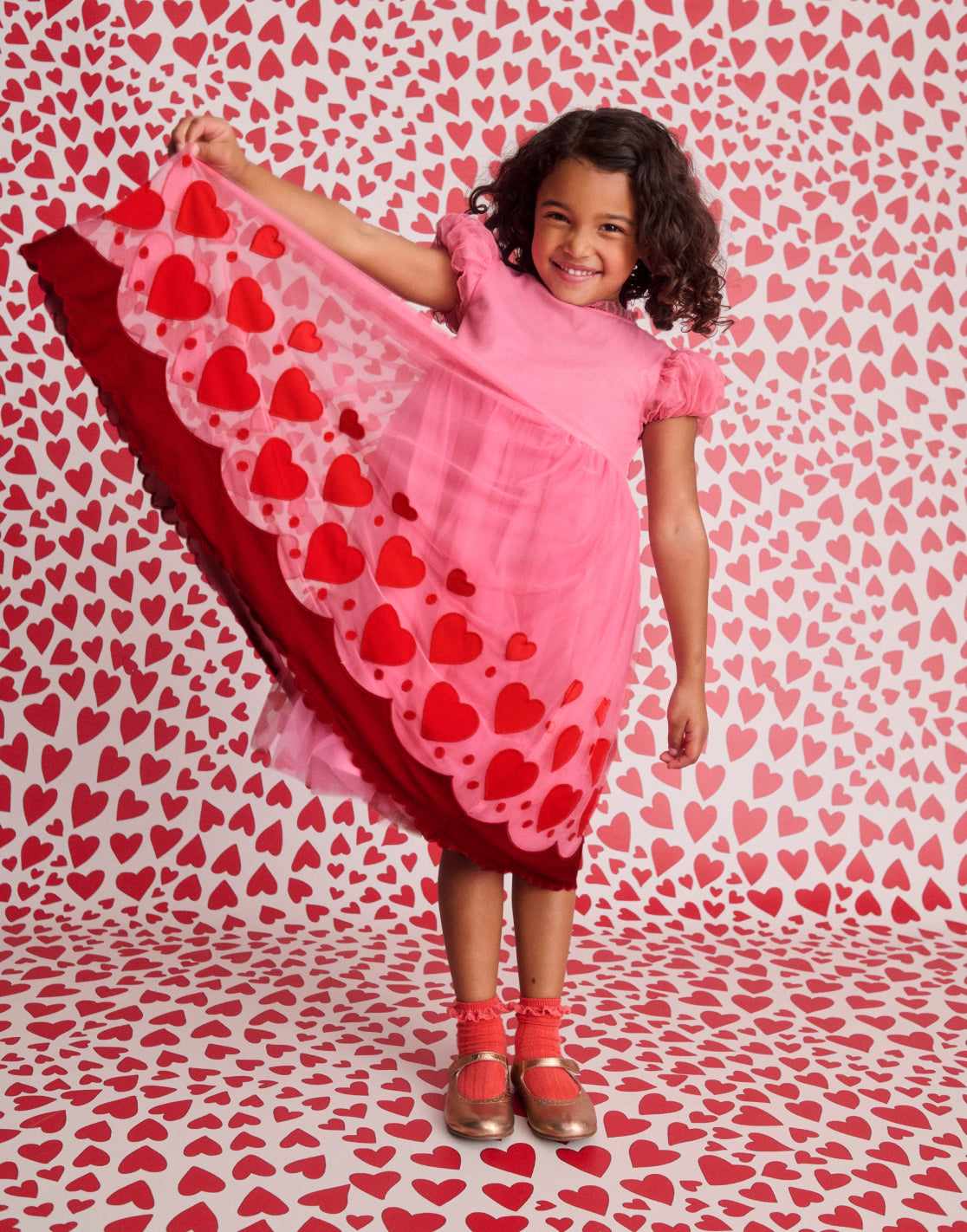 girl smiling while lifting up heart printed dress