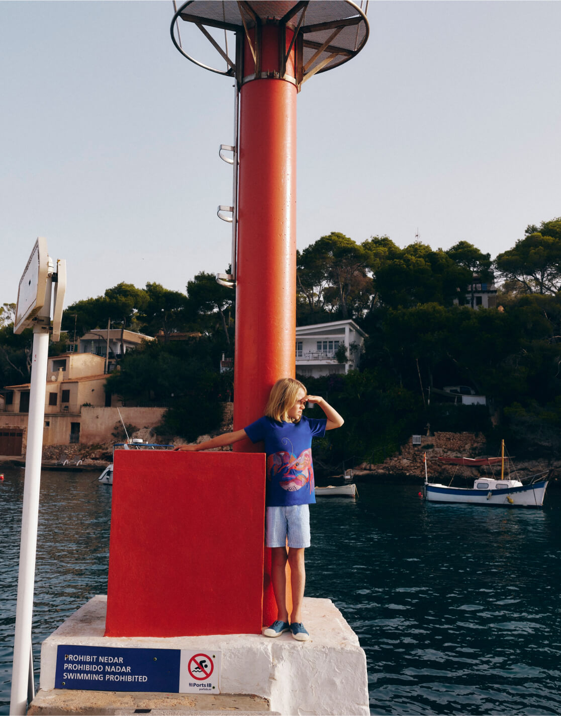 boy standing on rock near ocean 