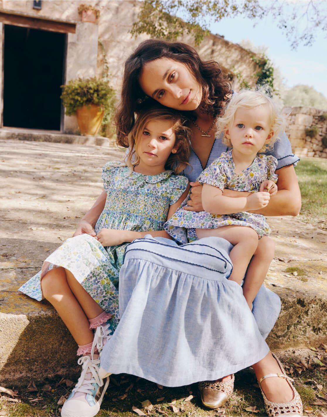 woman holding young girl and baby girl in her arms